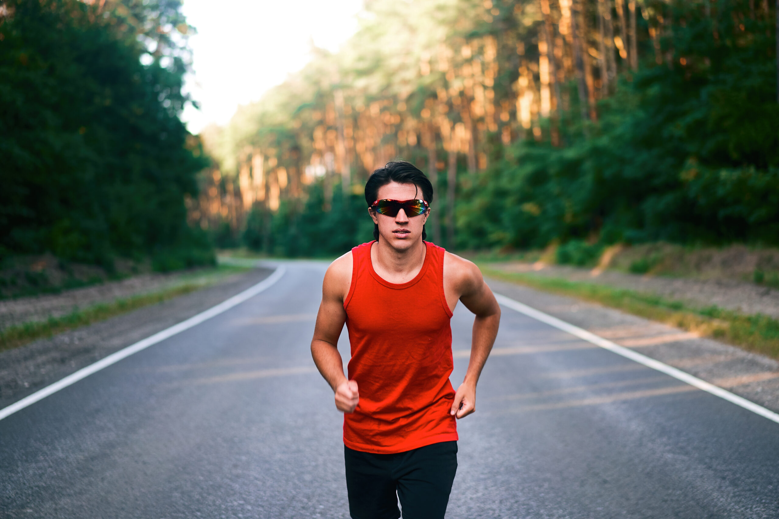 caucasian-middle-age-man-athlete-runs-sunny-summer-day-on-asphalt-road-in-the-forest